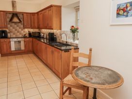 A kitchen with cabinets and appliances at Watermill Cottage in North Charlton