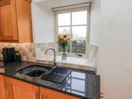 A kitchen with a sink and a window at Watermill Cottage in North Charlton