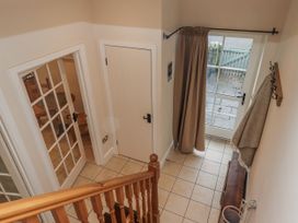 A hallway with stairs and a glass door at Watermill Cottage in North Charlton