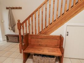 A hallway with a wooden bench and staircase at Watermill Cottage North Charlton