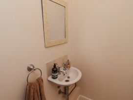 A bathroom with a sink and mirror at Watermill Cottage in North Charlton