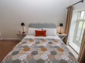 A bedroom with a bed and bedside tables at Watermill Cottage in North Charlton