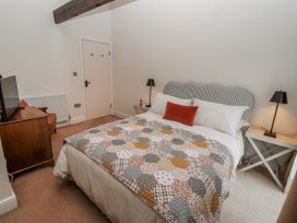 A bedroom with a bed and television at Watermill Cottage in North Charlton