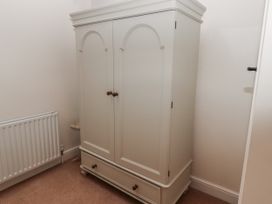 A wardrobe in a bedroom at Watermill Cottage North Charlton