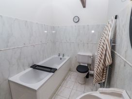 A bathroom with a bathtub and a toilet at Watermill Cottage in North Charlton