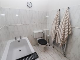 A bathroom with a bathtub and toilet at Watermill Cottage North Charlton