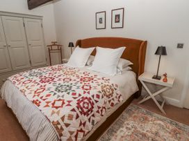 A bedroom with a large bed and wardrobe at Watermill Cottage in North Charlton