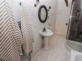 A bathroom with a sink, shower, and towels at Watermill Cottage in North Charlton