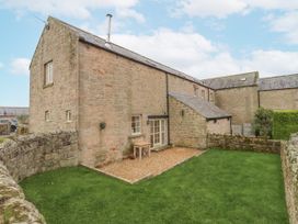An outdoor area with a stone building and a garden at Watermill Cottage in North Charlton