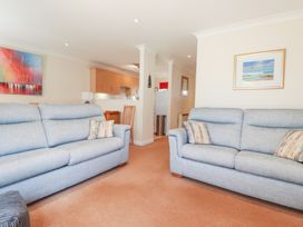 A living room with sofas and dining area at Trouts Reach in Falmouth
