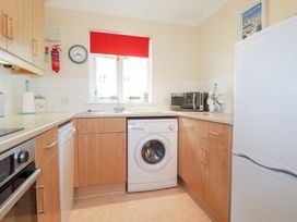 A kitchen with a washing machine and countertop at Trouts Reach Falmouth
