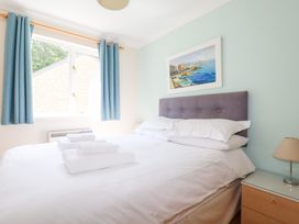 A bedroom with a bed and bedside table at Trouts Reach in Falmouth