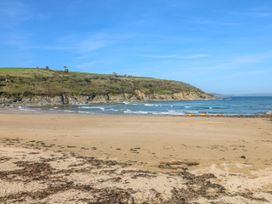 A beach with waves and a cliff at Trouts Reach in Goldenbank near Budock Water