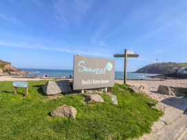 A sign for Swanpool Beach & Nature Reserve with grassy area at Swanpool Beach near Falmouth