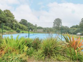 A tennis court surrounded by plants at Trouts Reach in Goldenbank near Budock Water
