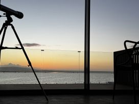 A telescope and chair overlooking water at Mostyn View in West Kirby