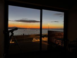 A living room with a telescope and a view of the sea at Mostyn View in West Kirby