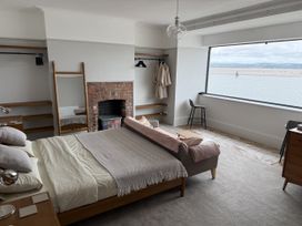 A bedroom with a bed and view of the water at Mostyn View in West Kirby