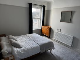 A bedroom with a bed, mirror, and dresser at Mostyn View in West Kirby