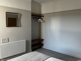 A bedroom with a mirror and shelves at Mostyn View, West Kirby