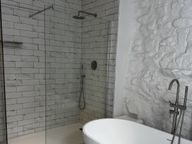 A bathroom with a glass shower and a bathtub at Mostyn View in West Kirby
