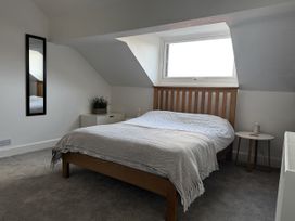 A bedroom with a bed and mirror at Mostyn View West Kirby