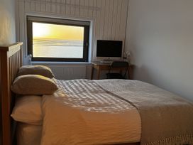 A bedroom with a bed and desk beside a window at Mostyn View in West Kirby