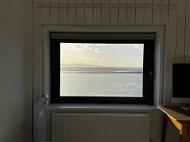 A view of water and mountains from a window at Mostyn View in West Kirby