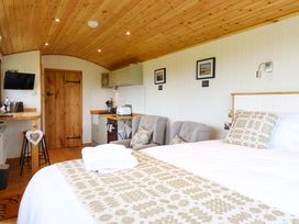 A bedroom with a bed and kitchenette at Defaid Cymreig Oswestry