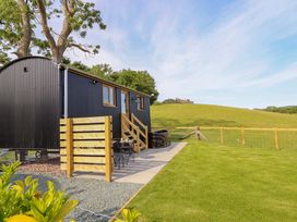 An outdoor space with a building, fence, and hot tub at Defaid Cymreig Oswestry