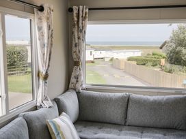 A living room with a view of the outdoor area at Puffin Way Holiday Caravan