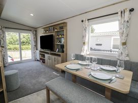A dining room with a table and chairs at Puffin Way Holiday Caravan