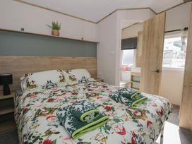A bedroom with a bed and towels on the sheets at Puffin Way Holiday Caravan