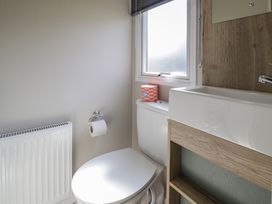 A bathroom with a toilet and sink at Puffin Way Holiday Caravan