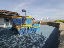 A playground with a pirate ship climbing structure at Puffin Way Holiday Caravan