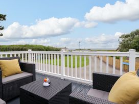 A deck with furniture and a view at 8 Puffin Way Llwyngwril