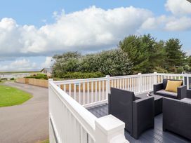 An outdoor deck with furniture at 8 Puffin Way Llwyngwril