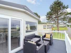 An outdoor seating area with chairs and a table at 8 Puffin Way Llwyngwril