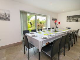 A dining room with a long table and chairs at Silver Copse in Frilford Heath Near Abingdon