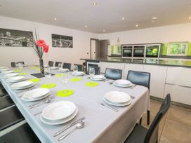 A dining room with a long table set for a meal at Silver Copse Frilford Heath Near Abingdon