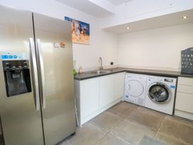 A kitchen with a refrigerator and washing machine at Silver Copse in Frilford Heath Near Abingdon