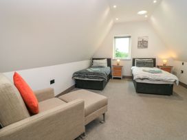 A bedroom with two beds and a seating area at Silver Copse Frilford Heath Near Abingdon