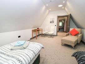 A bedroom with a bed and chairs at Silver Copse Frilford Heath Near Abingdon