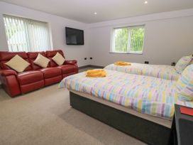A bedroom with two beds and a sofa at Silver Copse in Frilford Heath Near Abingdon