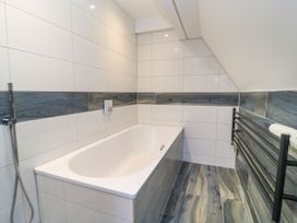 A bathroom with a bathtub and a towel radiator at Silver Copse Frilford Heath Near Abingdon