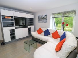 A living room with a sectional sofa and television unit at Silver Copse in Frilford Heath Near Abingdon