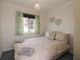 A bedroom with a bed and window at Cherry Tree in Kidlington