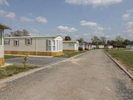 An outdoor area with mobile homes and a gravel road at Cherry Tree in Kidlington