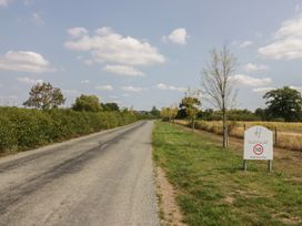 A road lined with trees and a sign at Heathfield Park in Kidlington