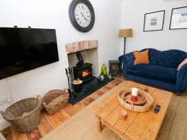 A living room with a television, fireplace and sofa at 18 Main Street